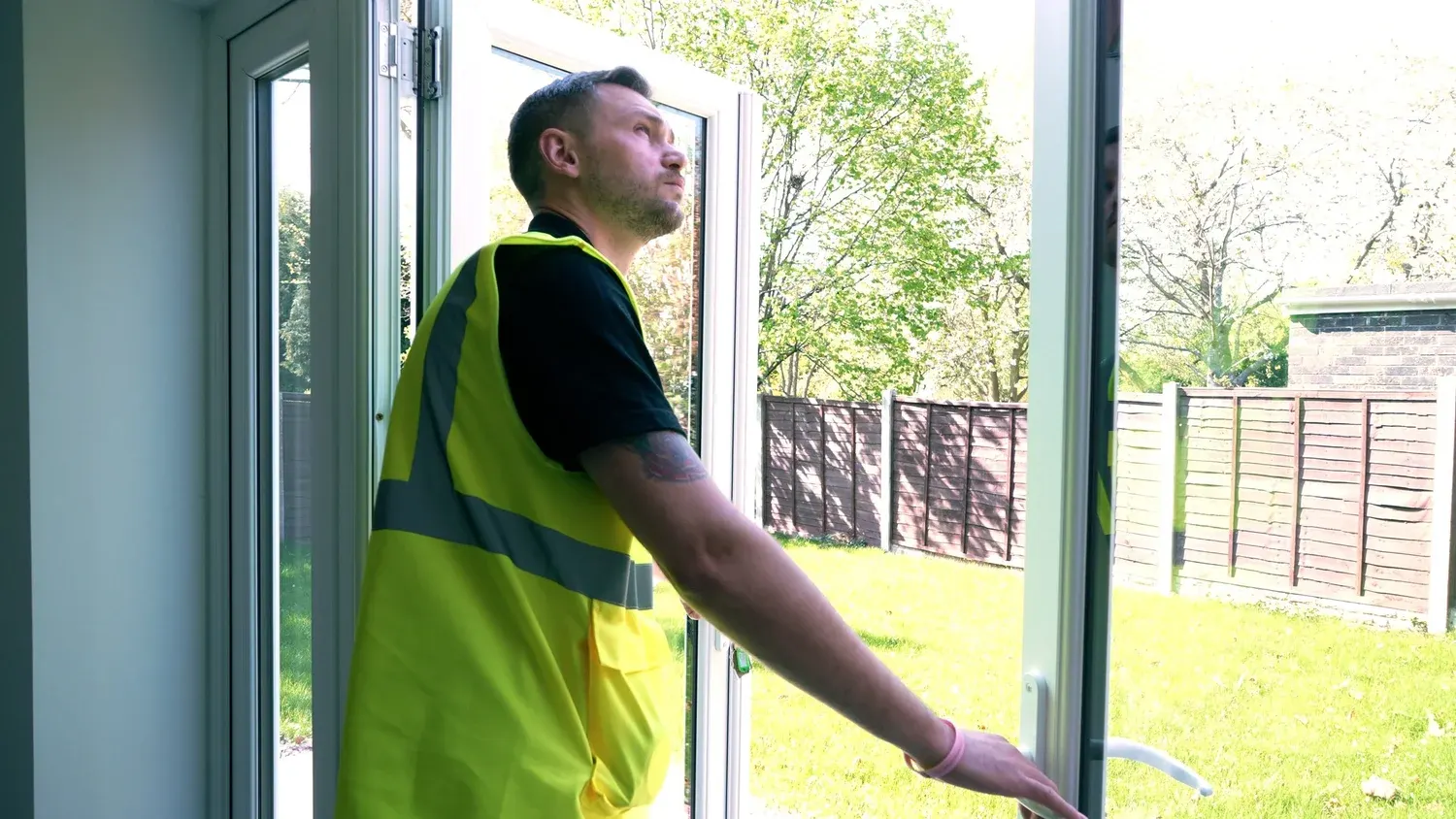 A Premier Snag inspector in hi-vis checking patio doors on a new-build home