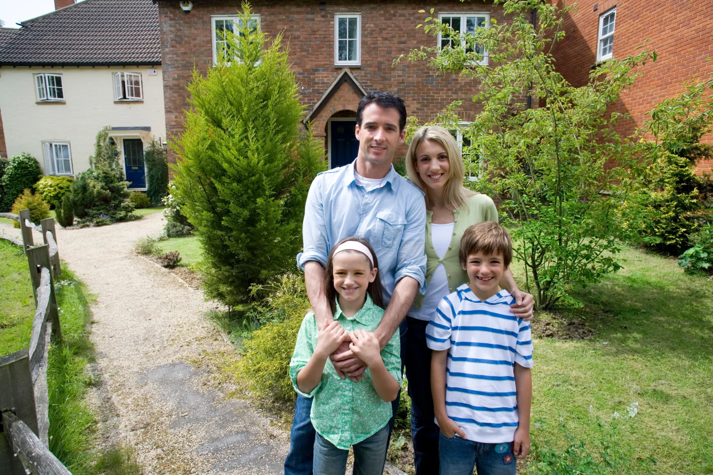 A family outside their new home being surveyed to the RICS Home Survey Standard, annotated with green, amber and red condition ratings.